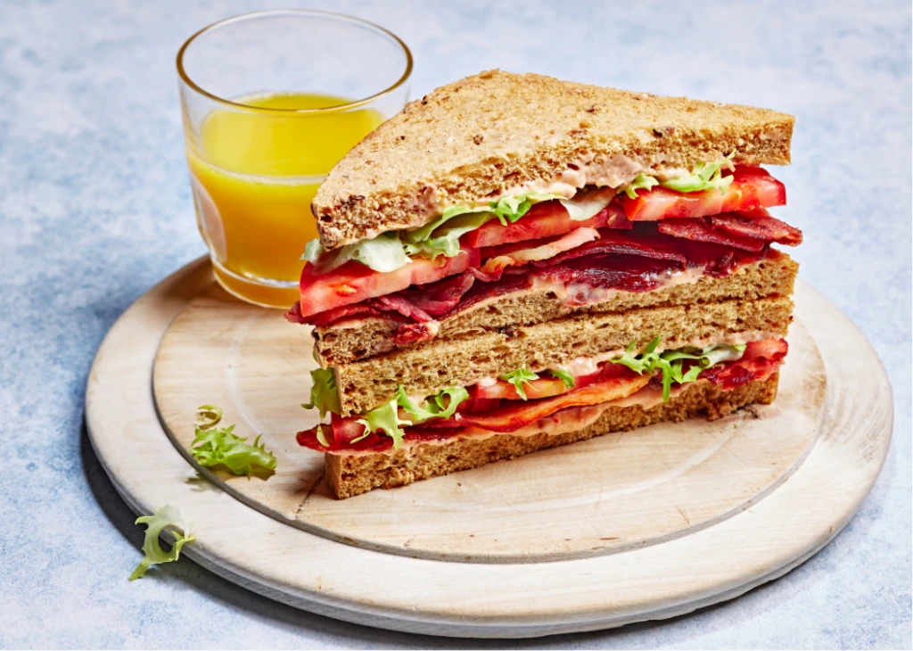Sandwich on a platter with orange juice